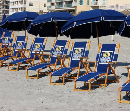 Frankford Avalon beach umbrellas shading a row of navy blue branded beach chairs at Myrtle Beach