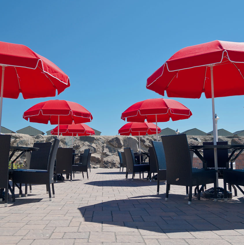 Six Frankford Catalina fiberglass patio umbrellas shading an outodoor dining area