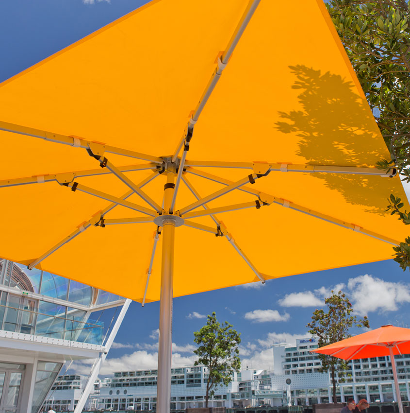 Square and yellow Frankford giant market umbrella outside of a large building
